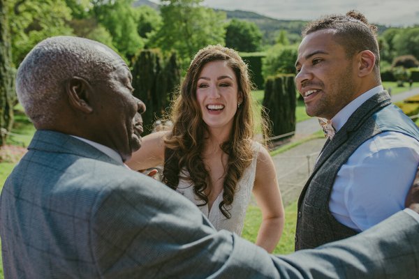 Father bride and groom exterior grass shot