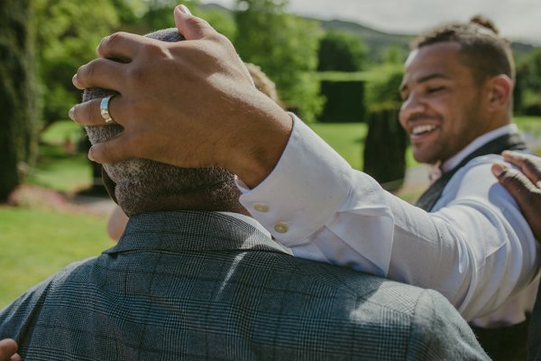 Grooms hand on fathers head wedding band/ring detail