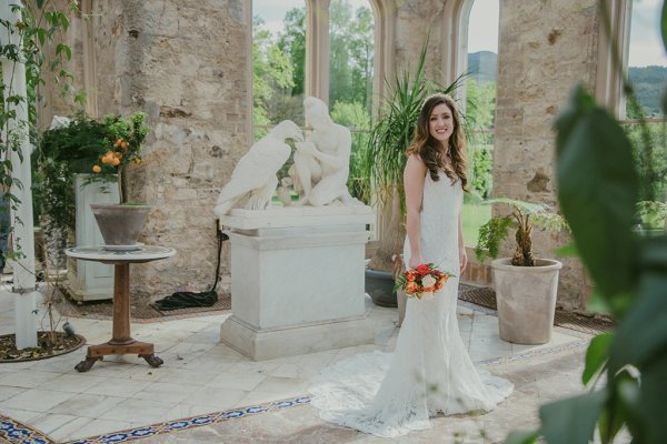 Bride on her own holding orange/red roses/bouquet greenhouse statues