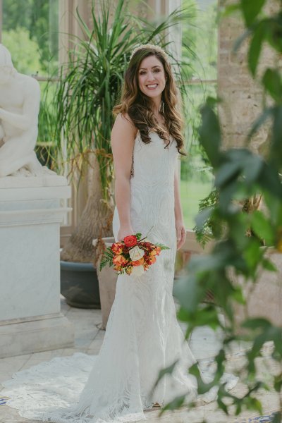 Bride on her own holding orange/red roses/bouquet greenhouse statues