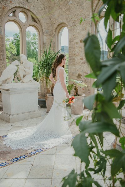 Bride on her own holding orange/red roses/bouquet greenhouse statues