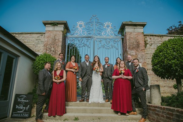 Family shot of bride groom groomsmen and bridesmaids on steps of wedding venue