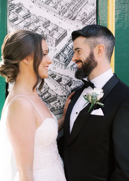 Bride and groom look at each other in front of house drawing sketch