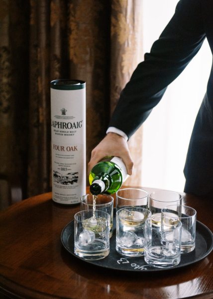 Waiter pours whiskey into glasses with ice