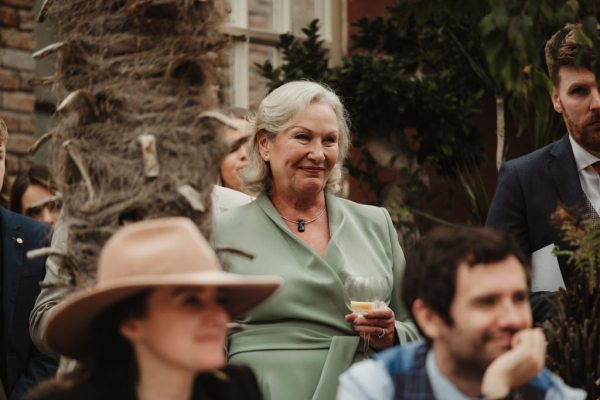 Lady in green smiling at the couple during speech