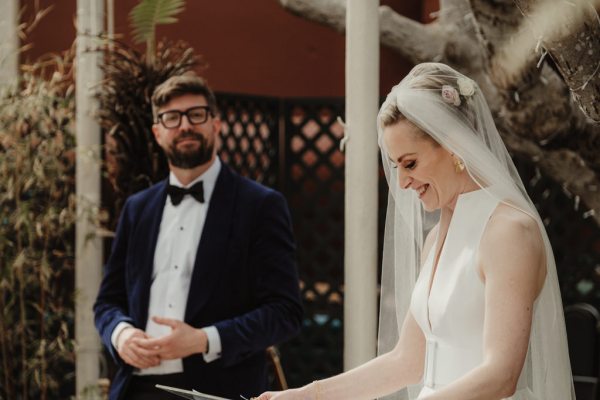 Bride wearing veil reads speech to guests