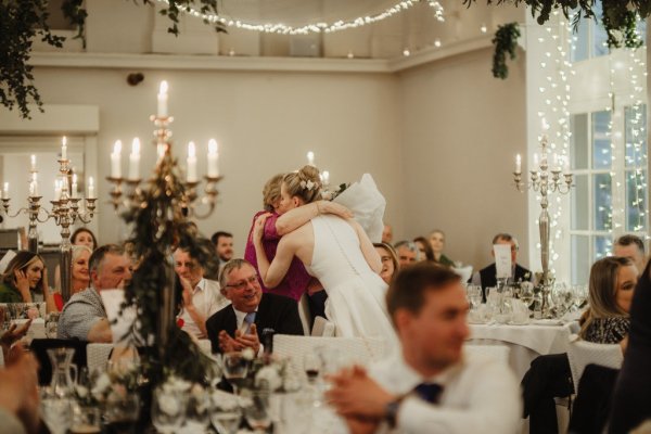 Bride hugs guest/woman