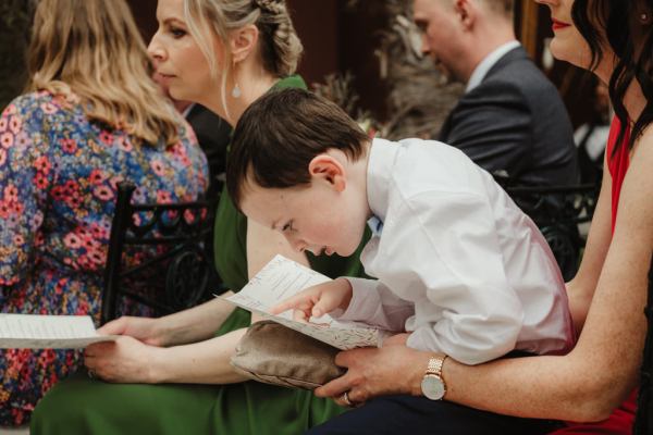 Little boy wearing shirt reading pamphlet