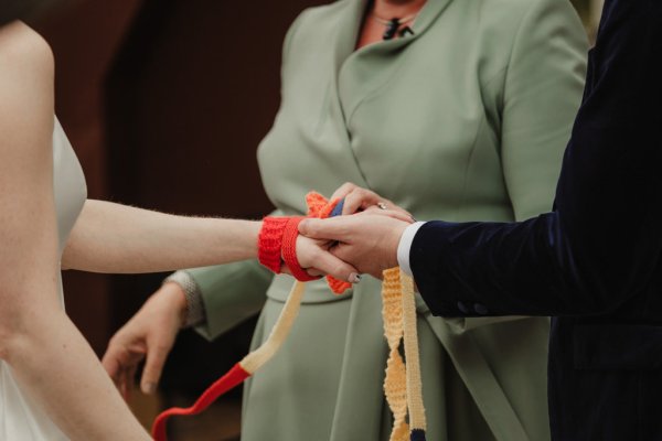 Bride and groom hands bound ribbon