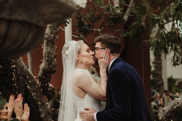 Bride and groom kiss at alter