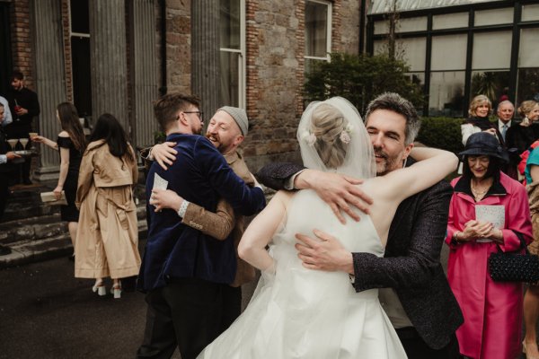 Man guest friend hugs bride