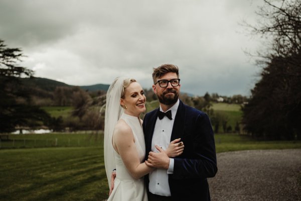 Bride and groom standing in park forest setting