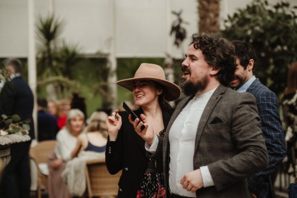 Woman wearing hat and man with phone