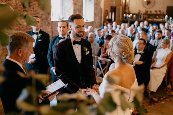 Bride and groom officiant at alter during ceremony and guests