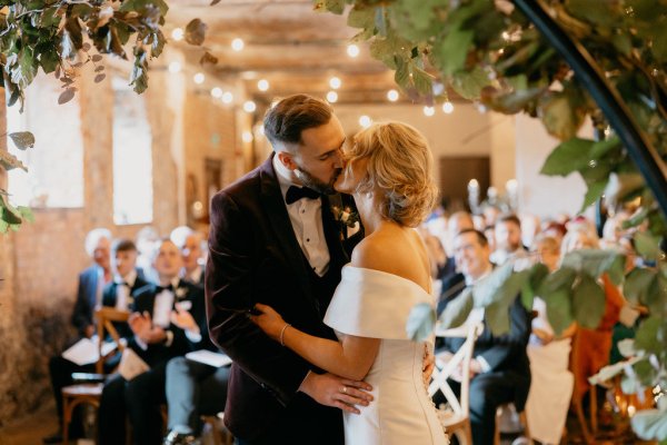 Bride and groom at alter kissing