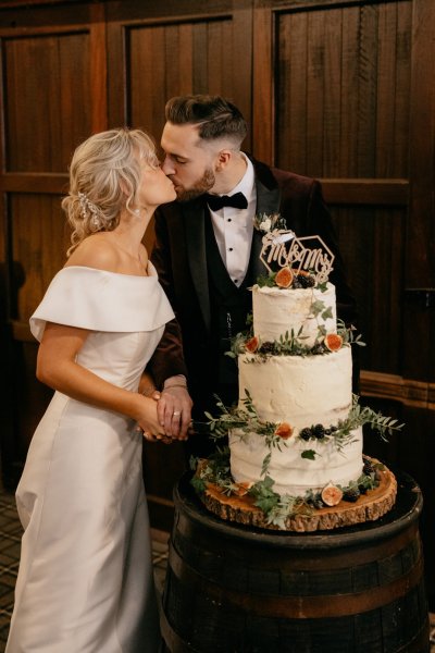 Bride and groom cutting the white wedding cake