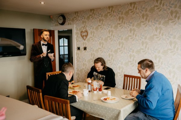 Groom and groomsmen sit down and eat dining room