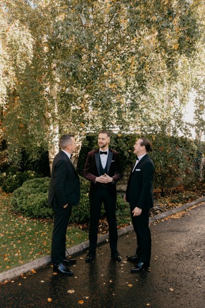 Groom and groomsmen standing in forest/park