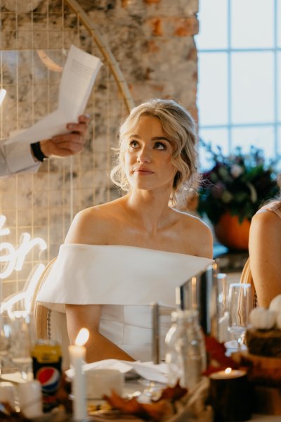 Bride looking at groom giving speech