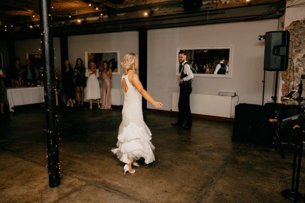 Bride and groom on dancefloor dancing guests watch