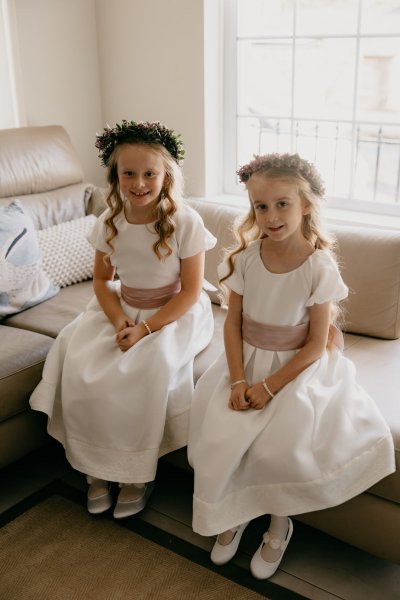 Little flower girls floral headbands sitting on sofa