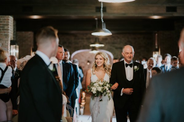 Father of the bride walks down the aisle guests