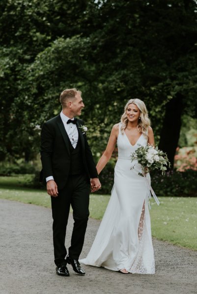 Bride and groom walking along pathway