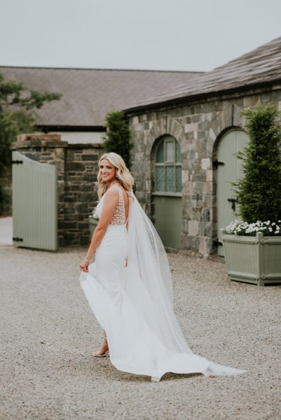 Bride looks behind her on farm