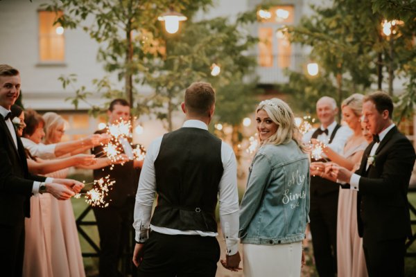 Mrs Summs denim jacket holding hands with groom over the shoulder