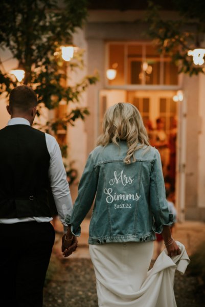 Mrs Summs denim jacket holding hands with groom