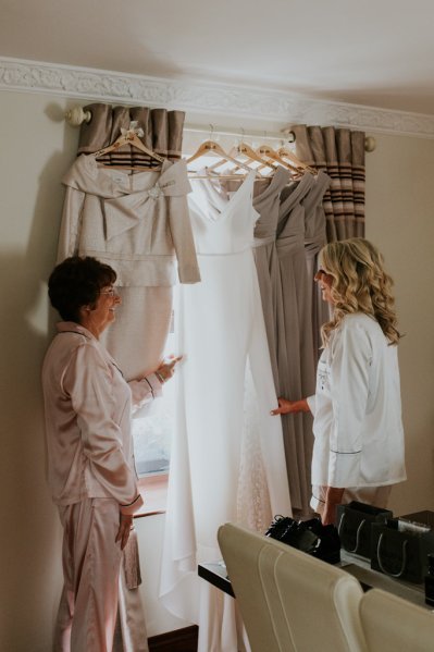 Bridal gown/dress is hanging at the window bride