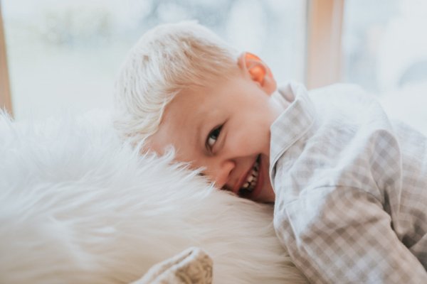 Little boy hugs soft feather fluffy cushion