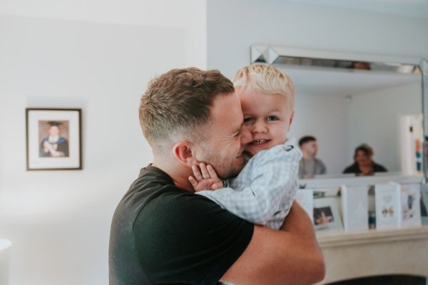 Father of little boy kisses him on the cheek hug embrace