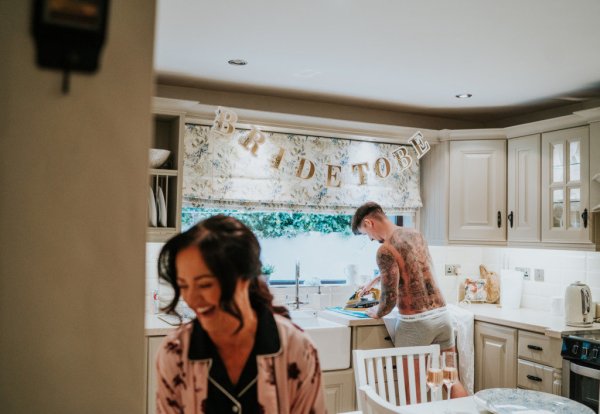 Bride to be sign guests mother getting ready in kitchen