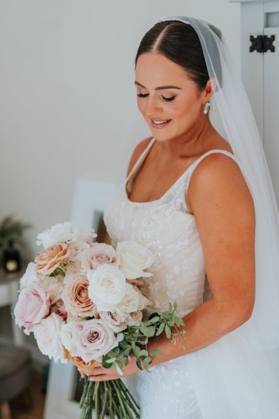 Bride holding bouquet of flowers/roses looking down