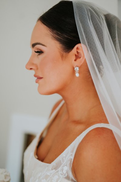 Close up of earring detail on bride