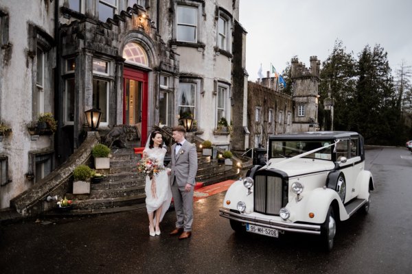 Bride and groom beside wedding car exterior wedding venue