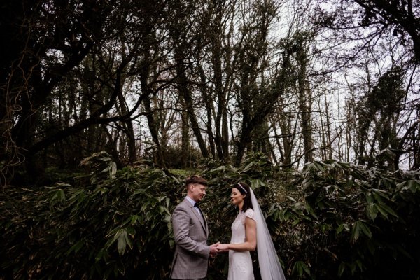 Bride and groom in front of tree detail forest park holding each other