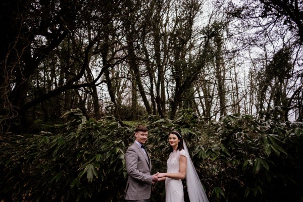 Bride and groom in front of tree detail forest park holding each other