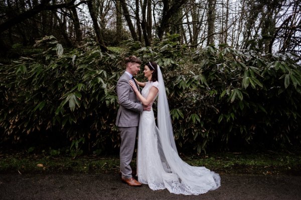 Bride and groom in front of tree detail forest park holding each other