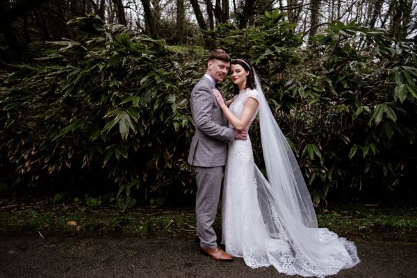 Bride and groom in front of tree detail forest park holding each other