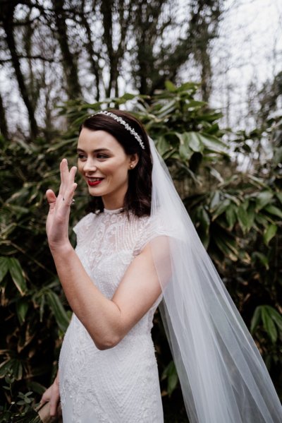 Bride in front of trees in forest park veil detail