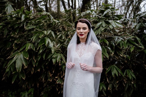 Bride in front of trees in forest park veil detail