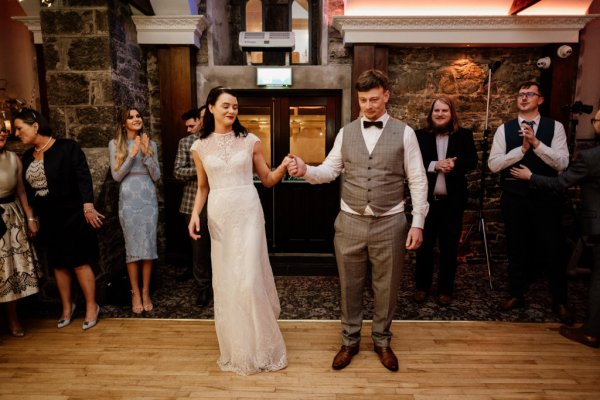 Bride and groom dance on the dancefloor in front of guests