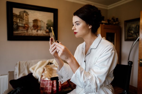 Makeup MUA bride and makeup artist getting ready looking in the mirror