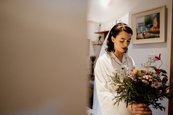 Bride holding bouquet interior house setting