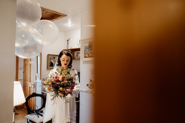 Bride holding bouquet interior house setting