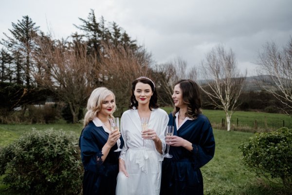 Bridesmaids and bride drinking champagne prosecco exterior park setting