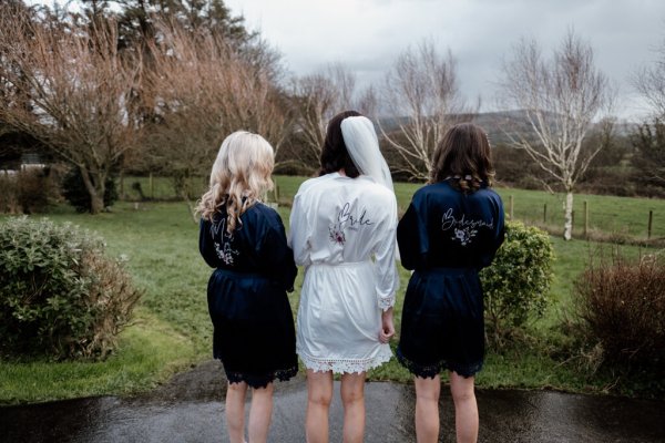 Behind shot of bridal loungewear and bride wearing veil exterior shot