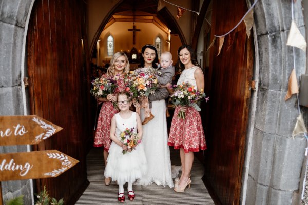 Family shot bride little girl father and mother flowers exterior church setting